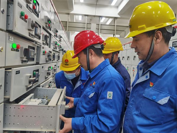 3月16日，對(duì)標(biāo)交流現(xiàn)場，大家圍在一起對(duì)配電室開關(guān)柜查找差距與優(yōu)勢.jpg