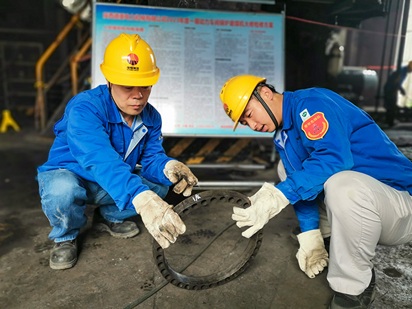 圖三：12日下午14時，在一期磨煤機(jī)廠房，陜西省技術(shù)能手姬霄給青工張跟潮講解磨煤機(jī)搖臂曲拐內(nèi)環(huán)及動作原理。.jpg